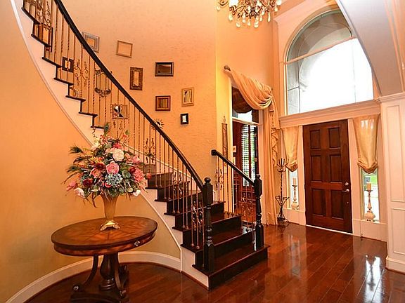Elegant entry offering two story high ceilings, hardwood floors and and stair with iron railing.