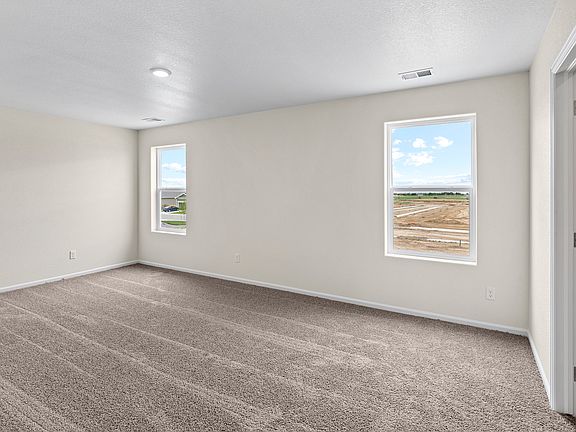 Master bedroom with two windows, making it a bright and open space.