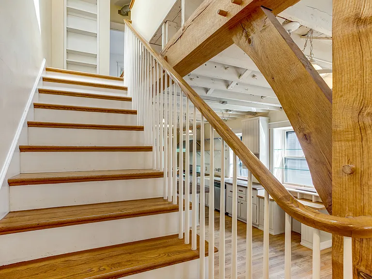 Stairs up to the second floor with a bookshelf at the top