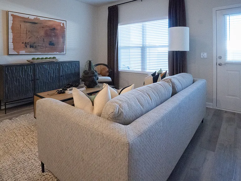 Living room with large couch and windows.