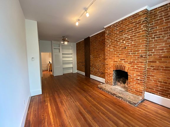 Living room has built in shelving, closet for storage.
