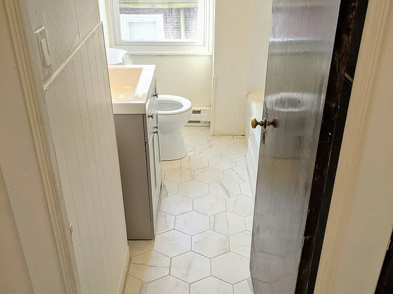 Remodeled bathroom with brand new vanity, tile, and toilet