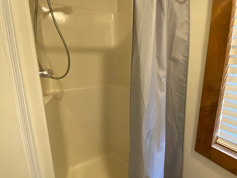 Half shower stall in lower level shared bath.