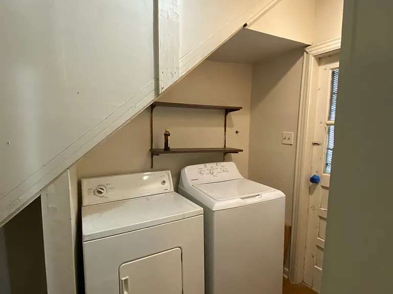 In unit laundry room with full size washer and dryer and extra storage closet.