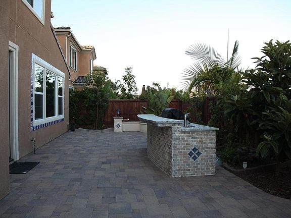 Outdoor kitchen with maintenance-free tropical fruit trees, beautiful tiled, granite BBQ island with sink and mini-fridge.