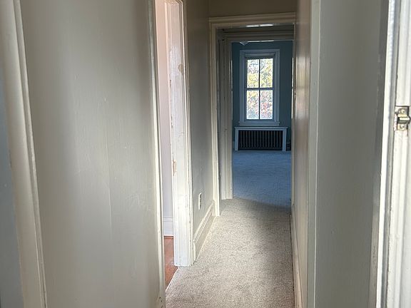 Hallway - POV standing in front of bathroom door. Bedroom with hardwood floors is first door on the left. The carpeted bedroom (not pictured) is immediately to the right. Pictured at the end of the hall is the living room/office.