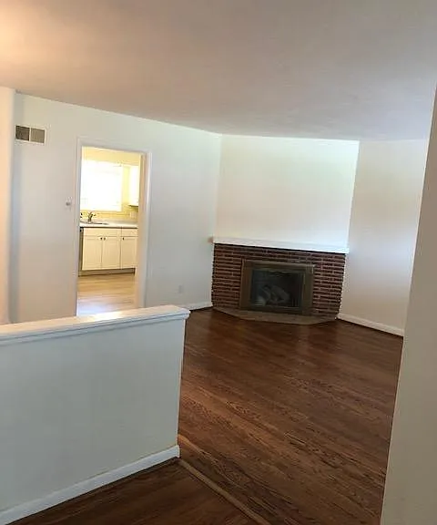 View of living room with fireplace (gas) and into kitchen.