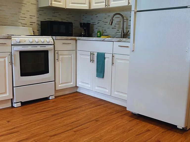 The kitchen is equipped with a refrigerator, coffee maker, and essential amenities.
