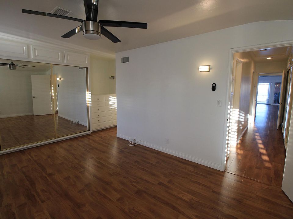 Master Bedroom with Ceiling Fan and Mirrored Closet Doors