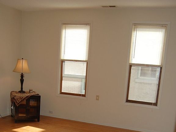 The living room is sunny and has an unusual, narrow-board hardwood floor
