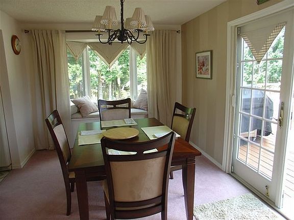 Formal dining room has bay window with built-in storage bench. French doors lead to large deck.