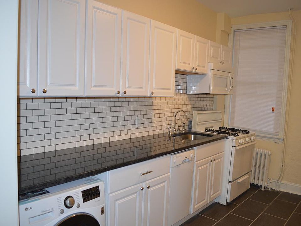 Newer kitchen with washer-dryer and microwave.