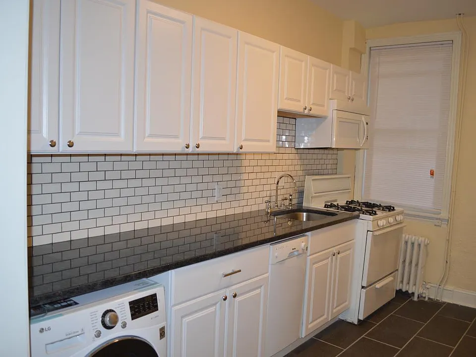 Newer kitchen with washer-dryer and microwave.