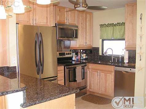 Kitchen with Stainless Kenmore Elite French drawer, matching Kenmore glass top electric range with overhead microwave, Bosch dishwasher, granite counter tops, under mounted sink, Moen fixtures, stainless like steel looking fan and decorative lighting.