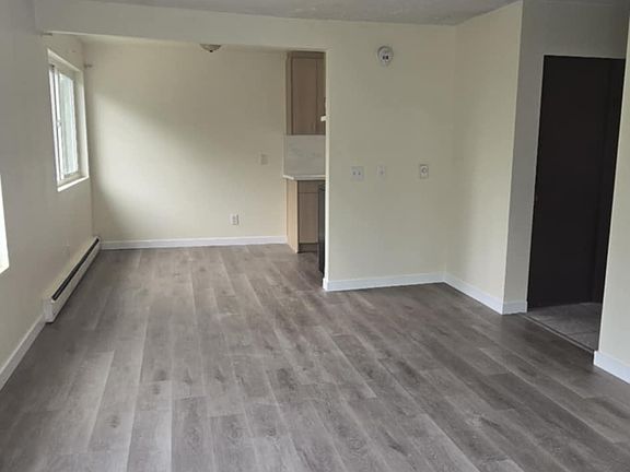 The living room is shown in the front of the photo. The dining room is shown in the back of the photo.