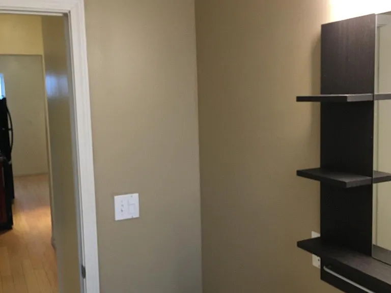Exiting bathroom with hall and kitchen/dining area in distance
