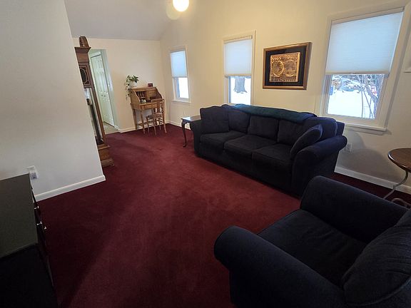 Large Furnished living room with plenty of natural light and cathedral ceilings. Radiant heat throughout entire apartment.