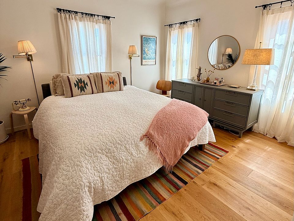 Light-drenched primary bedroom features a Cal king bed, Four Seasons mattress, flat-screen TV with Apple TV, Sonos speaker, large dresser, air purifyer and seating area.