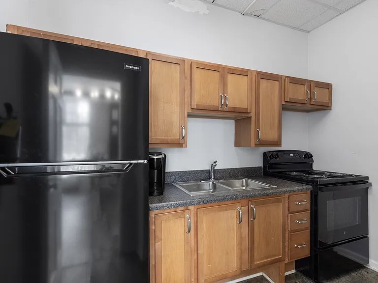 Kitchen with black appliances and light oak cabinetry