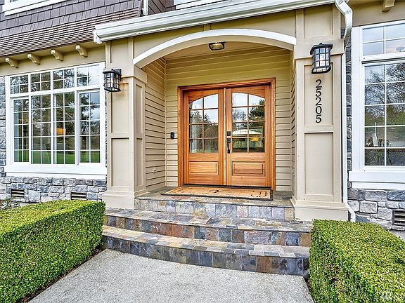 Covered Front Porch Features Updated Lighting Fixtures And A Newer (And Stunningly Gorgeous) Double Wood Door.