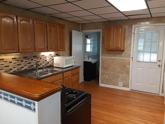 KITCHEN LOOKING AT BATHROOM AND REAR ENTRY DOOR