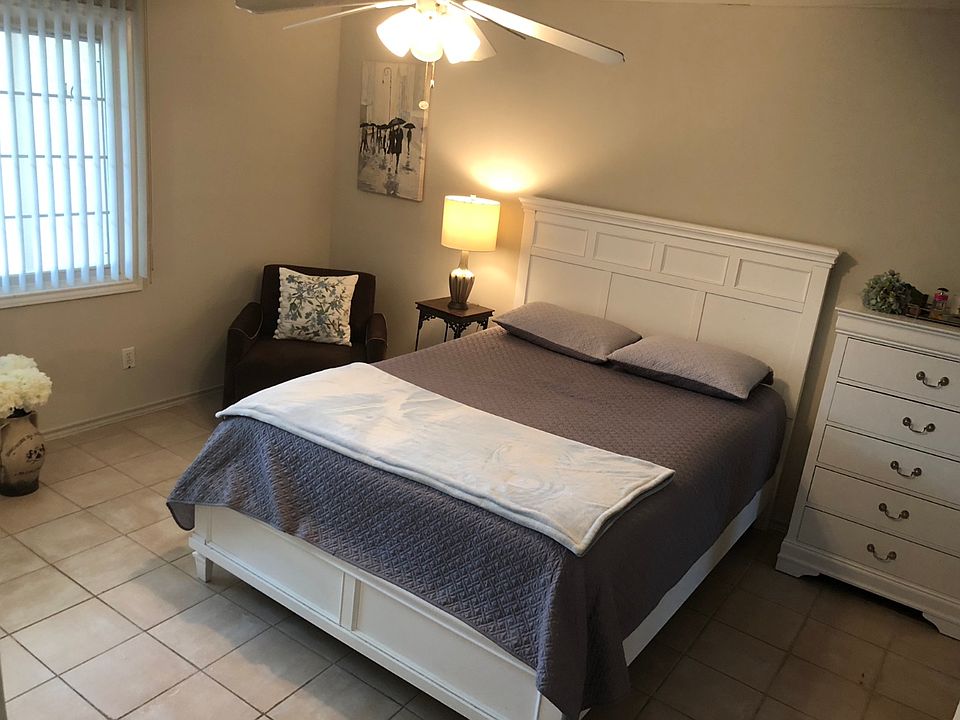 Large bedroom with an extension and clean tile floors.