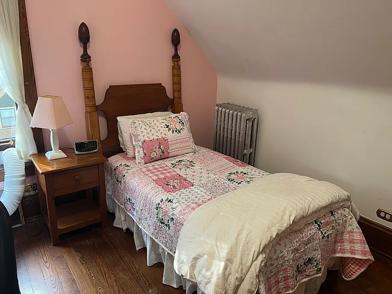 Dusty Rose Bedroom; one of three bedrooms fully equipped with desk, office chair, pine bed, pine dresser, pine bedside table, desk lamp, bookcase, alarm clock, waste basket, mini club chair, bed linens, and more.