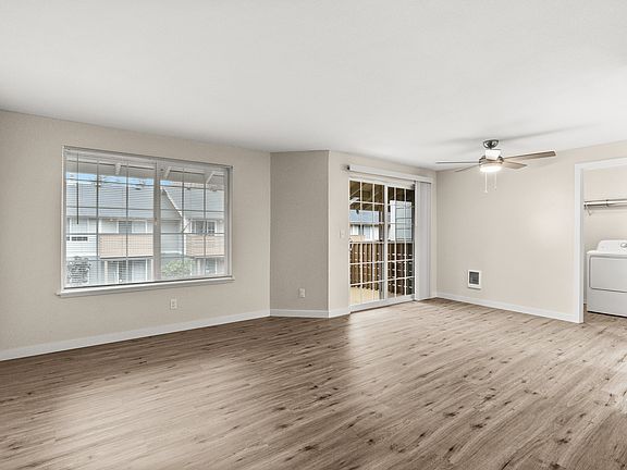 Bright and open living room with wood-style floors and private patio access.