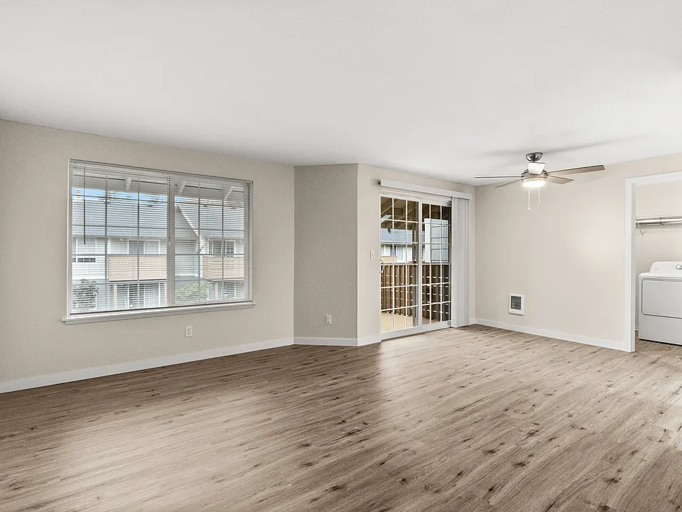 Bright and open living room with wood-style floors and private patio access.