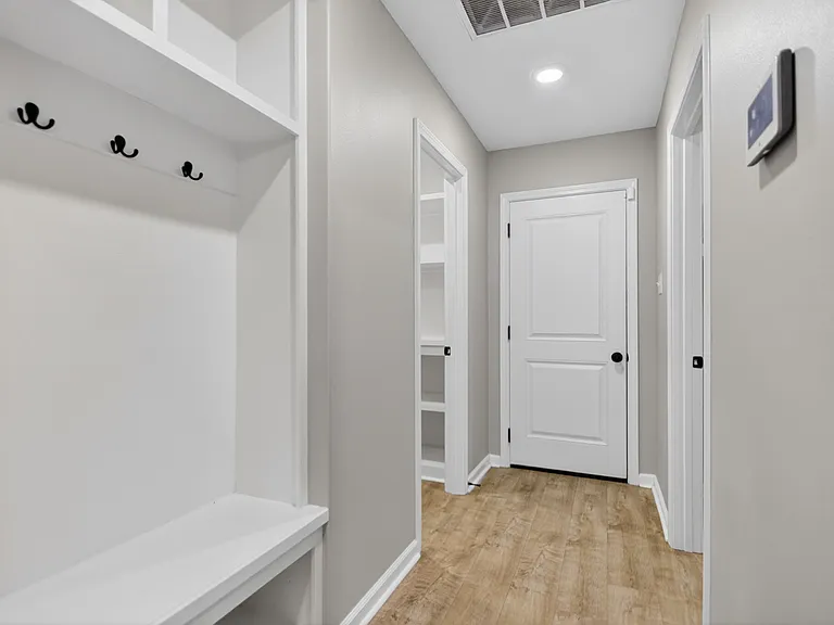 Entry hallway off garage. Door straight ahead goes to garage, pantry to left, laundry to right