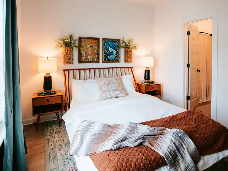 Mid-century modern charm meets comfort. Artwork and thoughtful decor make this bedroom a relaxing retreat.