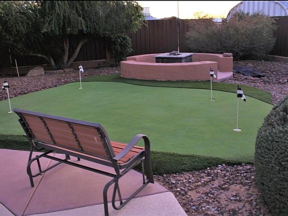 private putting green with lots of sitting area and fire pit