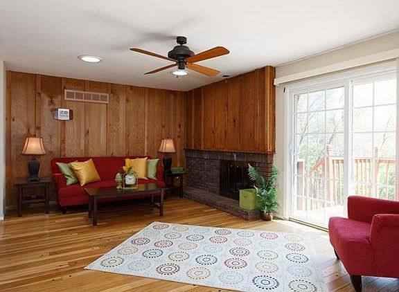Family room with wood burning fireplace and newer slider to deck overlooking level private yard