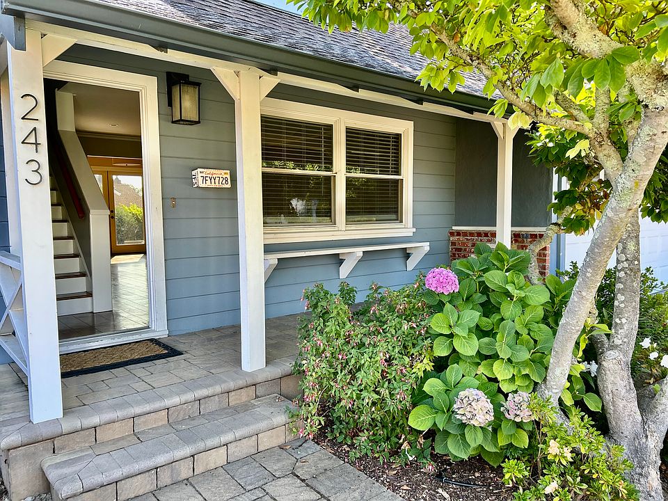 Paved pathway to front door with landscaping and covered porch