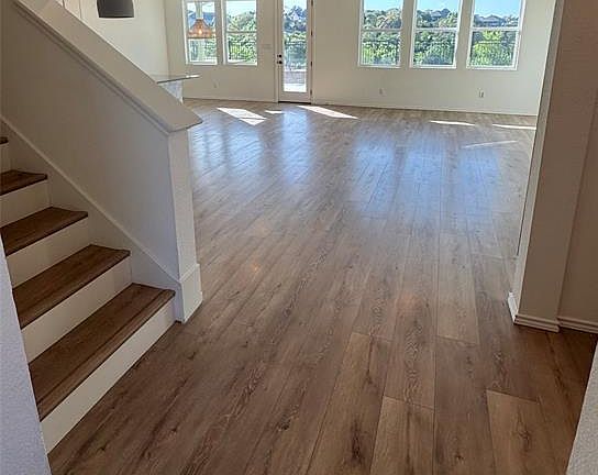 Unfurnished living room featuring light wood-style floors, stairway, a ceiling fan, and recessed lighting