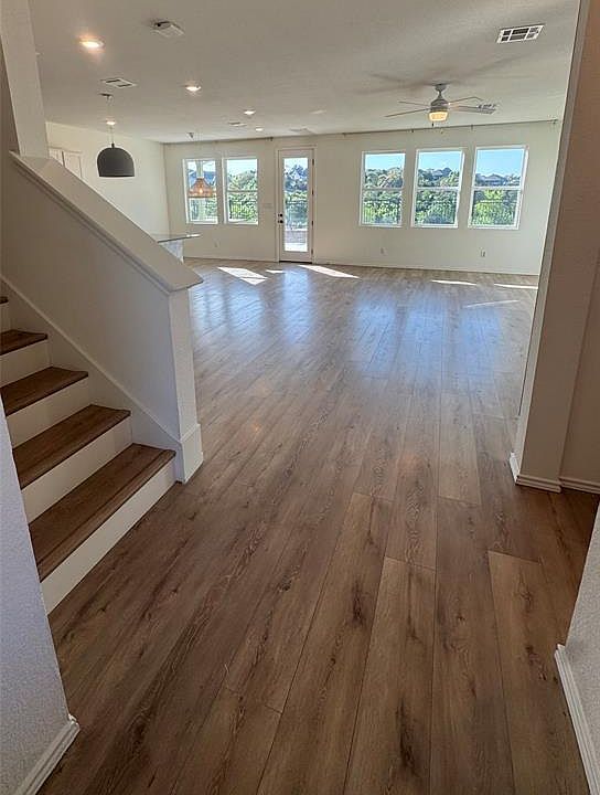 Unfurnished living room featuring light wood-style floors, stairway, a ceiling fan, and recessed lighting