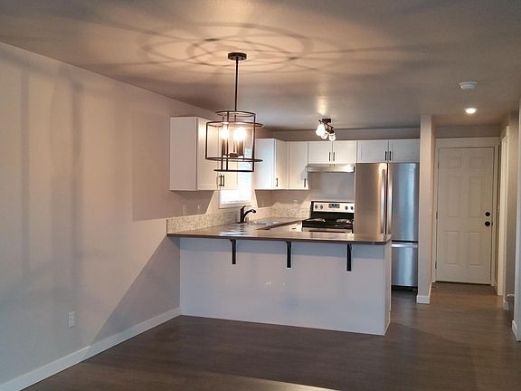 Standing in living room looking towards dining area, counter top breakfast bar/kitchen, and back door.