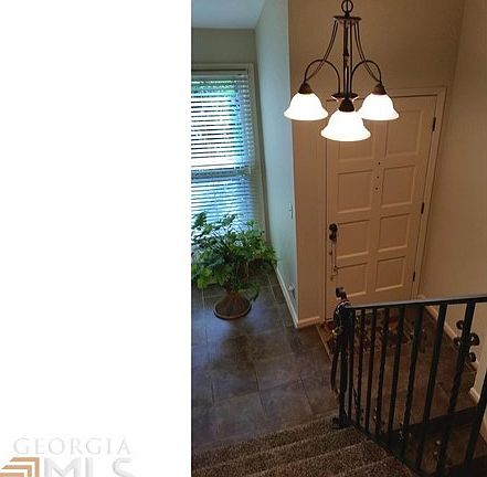View from upstairs hall in two-story foyer to the front door.