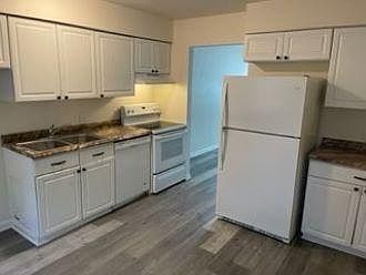 Kitchen with appliances, door to living room