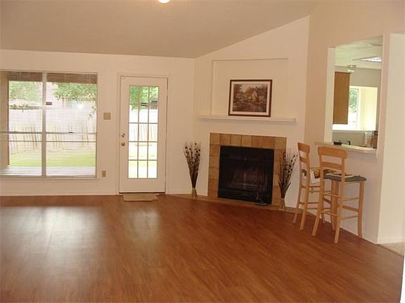 Great Room has laminate floor and opens to kitchen and kitchen dining (Tile) Step from Great Room on
