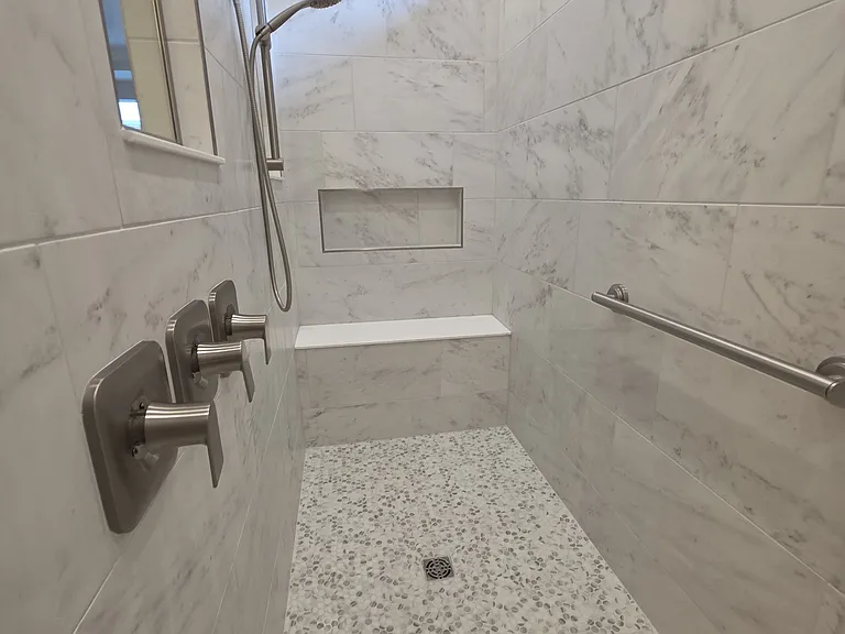 Beautiful tile in the primary shower. Room for two with seating!