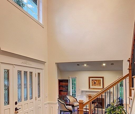 The charming leaded glass entry leads to the 2 story foyer with new contemporary chandelier, crown molding and wainscoted walls.
