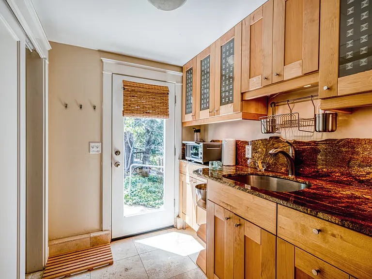 Private Entrance, travertine flooring in kitchenette. Granite countertops, wood cabinet doors. 10 cubic ft refrigerator, sliding closet doors for clothing and food. Wood cabinets.