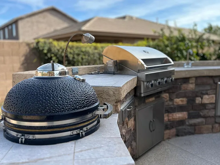 Amazing grill area equipped with an egg, a sink and gas grill!