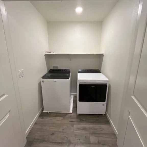 washer and dryer next to bathroom in upstairs