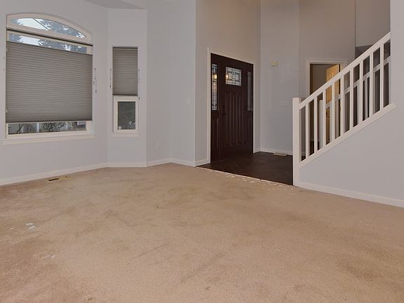Front room looking towards front door Door just past stairs leads to Office. 