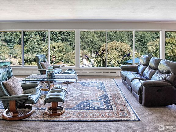 Floor to ceiling wall of windows welcomes you home and offers beautiful year-round views of your private backyard gardens.>