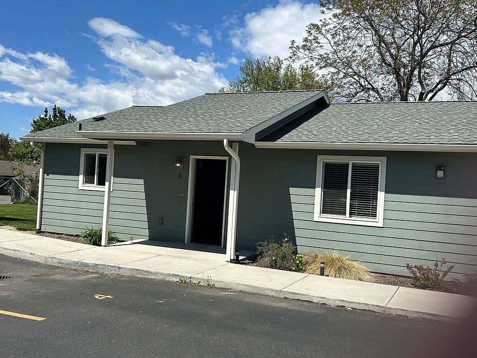 Front of unit with grassy area to side.