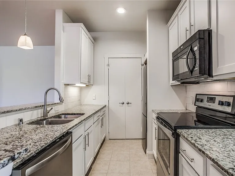Granite countertops, stainless steel appliances, updated cabinetry and sleek backsplash add style to this home