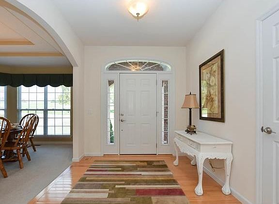 Entry has beautiful door with sidelites and elliptical windows, flooring is maple, dining room has double coffer ceilings and arched opening